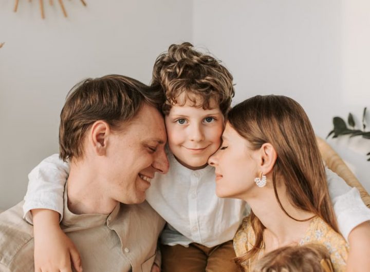 A joyful family moment with parents and their son embracing indoors.
